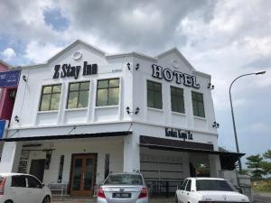 a hotel with cars parked in front of it at Z Stay Inn Hotel in Kampong Sahari
