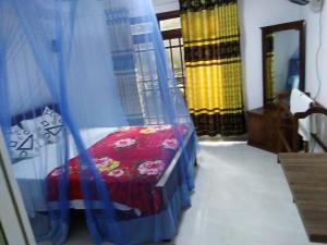a bedroom with a bed with a blue curtain at Ella Jayamali Homestay in Ella