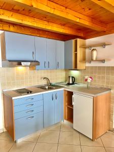 a kitchen with blue cabinets and a sink at Vespera Apartments in Bol