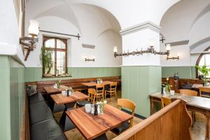 a restaurant with wooden tables and green walls at Hotel Der Löwen in Hagnau