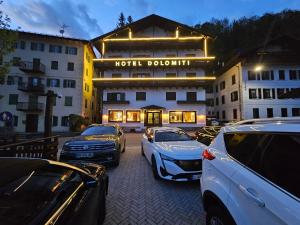 um quarto de hotel com carros estacionados em frente em Hotel TEA DOLOMITI - Lago di Alleghe - Monte Civetta em Alleghe mais 71 fotografias