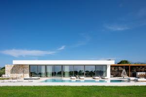 a villa with a swimming pool and lounge chairs at Cresto Iconic Villa, with Heated Spa Whirlpool, By ThinkVilla in Angeliana