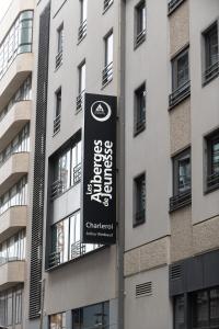 a sign on a pole in front of a building at Auberge de Jeunesse Charleroi Youth Hostel in Charleroi