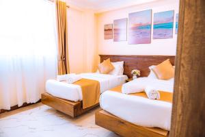Cette chambre comprend 2 lits et une fenêtre. dans l'établissement Kije Place Hotel, à Nairobi