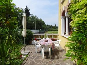 une terrasse avec une table, des chaises et un parasol dans l'établissement Appartamento Verdi Colline, à Moniga del Garda