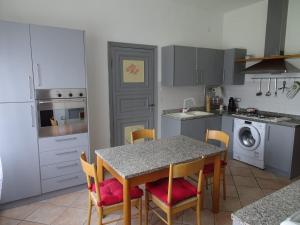 une cuisine avec une table et des chaises et une cuisine avec un lave-linge dans l'établissement Appartamento Verdi Colline, à Moniga del Garda