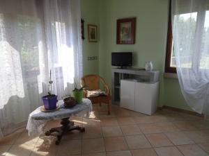 - un salon avec une table et une télévision dans l'établissement Appartamento Verdi Colline, à Moniga del Garda