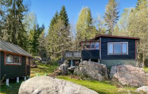 a cabin in the woods next to some rocks at 3 Bedroom Stunning Home In Fristad in Fristad