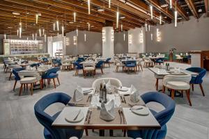 a dining room with tables and chairs and lights at Royal M Al Aqah Beach Resort by Gewan in Al Aqah