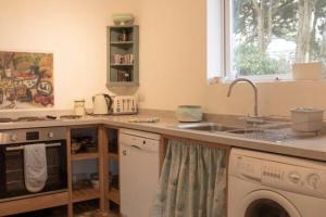 3 Linkside, Thurlestone, South Devon, family home close to the beach في ثورليستون: مطبخ مع مغسلة وغسالة ملابس