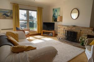 a living room with a couch and a fireplace at 3 Linkside, Thurlestone, South Devon, family home close to the beach in Thurlestone