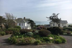 3 Linkside, Thurlestone, South Devon, family home close to the beach في ثورليستون: منزل مع حديقة في وسط شارع