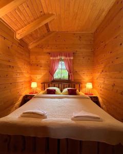 a bedroom with a bed in a wooden cabin at Apartments Zafran in Smoljanac