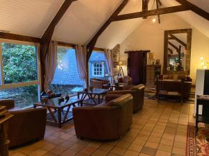 a living room with chairs and tables and windows at Les Moulins Du Duc ÉCOLODGE in Moëlan-sur-Mer