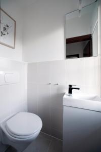 a white bathroom with a toilet and a sink at Ferienwohnung im Haus am See in Klein Upahl