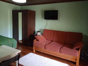 a living room with a couch and a tv on the wall at Quinta dos Campos - Apartamento 1 in Braga