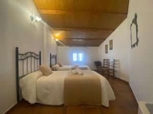 1 Schlafzimmer mit 2 Betten und Holzdecke in der Unterkunft Casa Rural del Pantano 4 Estrellas 