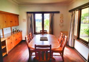 una sala da pranzo con tavolo e sedie in legno di Warradale Lodge and Mini Golf 