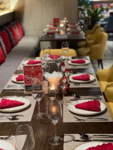 a long table with plates and wine glasses on it at Toà Nhà Apec Mandala Wyndham Phú Yên in Tuy Hoa