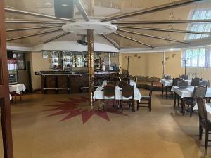 a restaurant with tables and chairs and a bar at Grand Hotel in Mohyliv-Podilʼsʼkyy