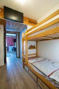 a bedroom with two bunk beds and a living room at Aux pieds des pistes, Les 2 Alpes in Vénosc