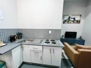 a small kitchen with a sink and a stove at Mocha Apartment next to Maboneng in Johannesburg