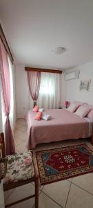 - une chambre avec 2 lits avec des draps roses et un tapis dans l'établissement Loula's House, à Spetses