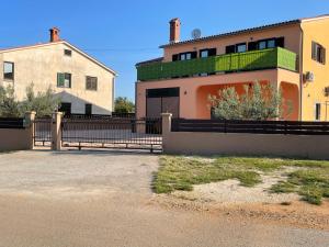 une maison avec une clôture à côté d'un bâtiment dans l'établissement Villa Rosa Apartman, à Loborika