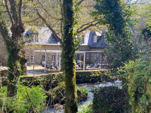 a house with a river in front of it at Les Moulins Du Duc ÉCOLODGE in Moëlan-sur-Mer