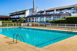ein großes Schwimmbad vor einem Gebäude in der Unterkunft Village Vacances Azureva Anglet in Anglet