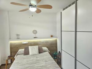 een slaapkamer met een bed en een plafondventilator bij HOLIDAYS CITY CENTER, Los Cristianos Beach in Arona