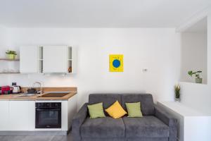 a living room with a couch with two yellow pillows at KHL APARTMENTS - SanSiro, Milano in Milan