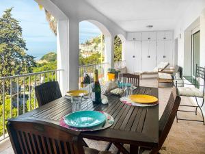 a wooden table with plates on top of a balcony at Sta Barbara 9 Canyelles Roses - Immo Barneda in Roses