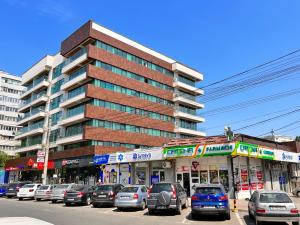 a parking lot with cars parked in front of a building at 2 rooms Airy & Bright Palas Park in Iaşi