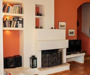 a living room with a fireplace and a tv at Agrilis Home in Filiatra