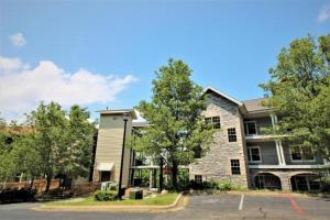 un edificio de apartamentos con un árbol delante de él en Branson's Great Rock Retreat en Branson