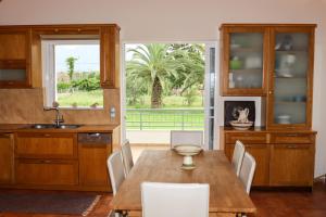 a kitchen with a wooden table and chairs and a window at Agrilis Home in Filiatra