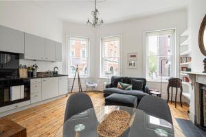 a living room with a couch and a table at ALTIDO Chic flat with private terrace near Kensington Palace in London