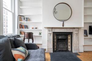 a living room with a couch and a mirror at ALTIDO Chic flat with private terrace near Kensington Palace in London