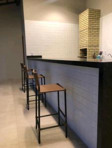 a bar with two chairs and a counter in a room at Ap Remanso in Barreirinhas