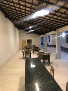 Un comedor con mesas y sillas y un mostrador negro. en Ap Remanso - Cond Lençois Confort Barreirinhas, en Barreirinhas