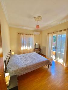 a bedroom with a bed and a large window at Dimitris apartment in Diakopto