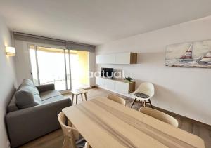 ein Wohnzimmer mit einem Tisch und einem Sofa in der Unterkunft Alexandra C-4 in Platja  d'Aro