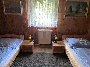 two twin beds in a room with a window at U myslivce in Chřibská