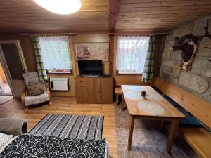 Zimmer mit einem Bett und einem Tisch in einer Hütte in der Unterkunft U myslivce in Chřibská