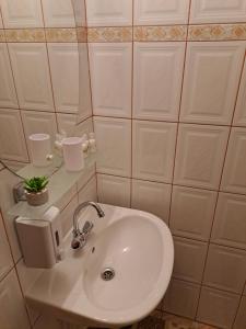 a bathroom with a white sink and a mirror at 7 Levél Panzió, Ultra Central, Self Check-in, Self-Catering in Miercurea-Ciuc