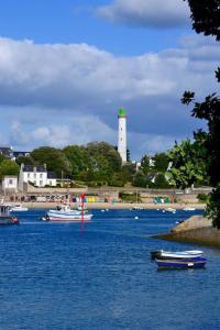 a group of boats in a body of water with a lighthouse at Les Marines du Treustel in Combrit