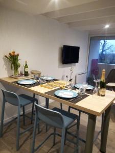 a large wooden table with chairs and wine bottles at Les Marines du Treustel in Combrit
