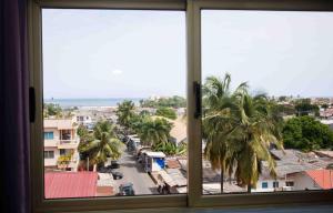 una ventana con vistas a una ciudad con palmeras en Prestige Suites, en Accra
