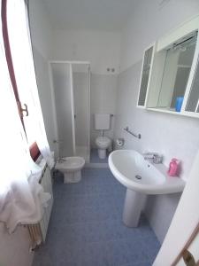 a white bathroom with two toilets and a sink at Affittacamere L'Arco in Volastra